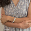 Woman wearing companion bracelet and gold bracelet