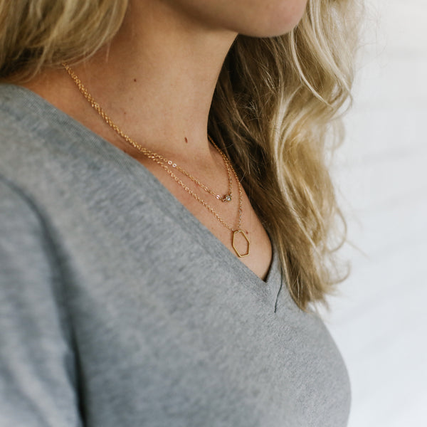 Woman wearing layered gold necklaces