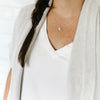 Woman wearing Together adoption silver necklace with triangle and heart