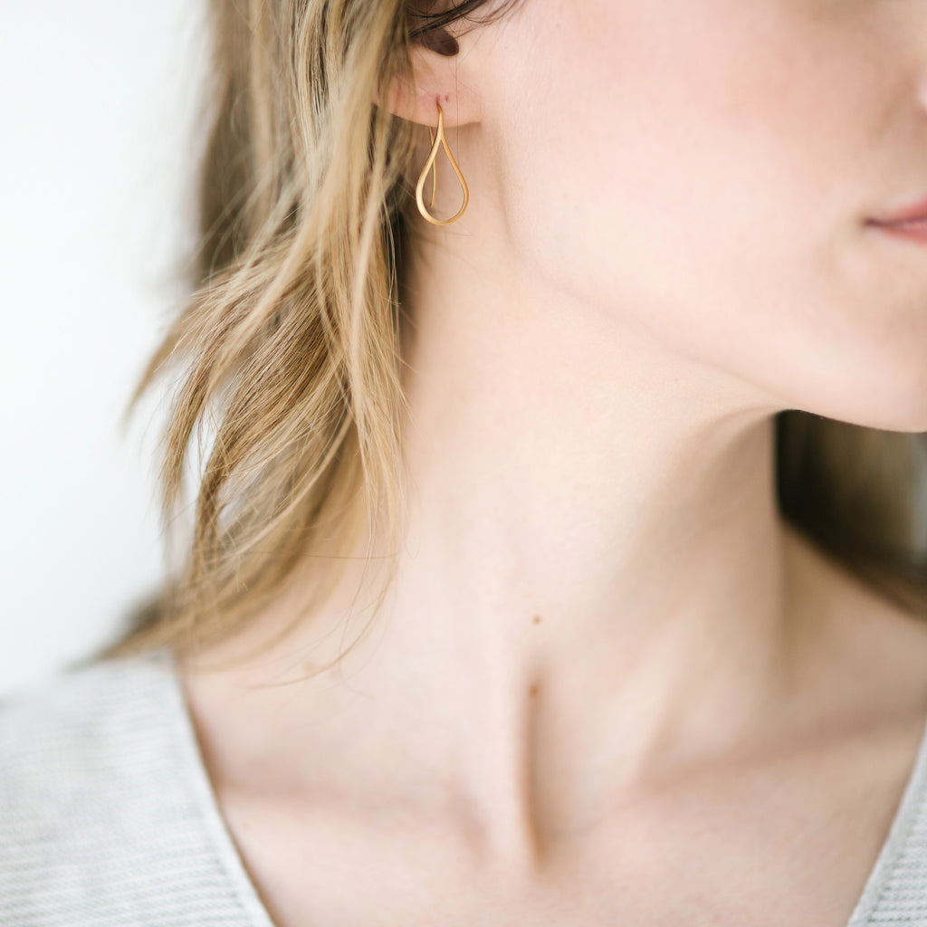 Woman wearing Storm gold earrings