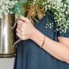 Woman wearing gold believe bracelet