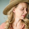 Woman wearing Storm gold earrings