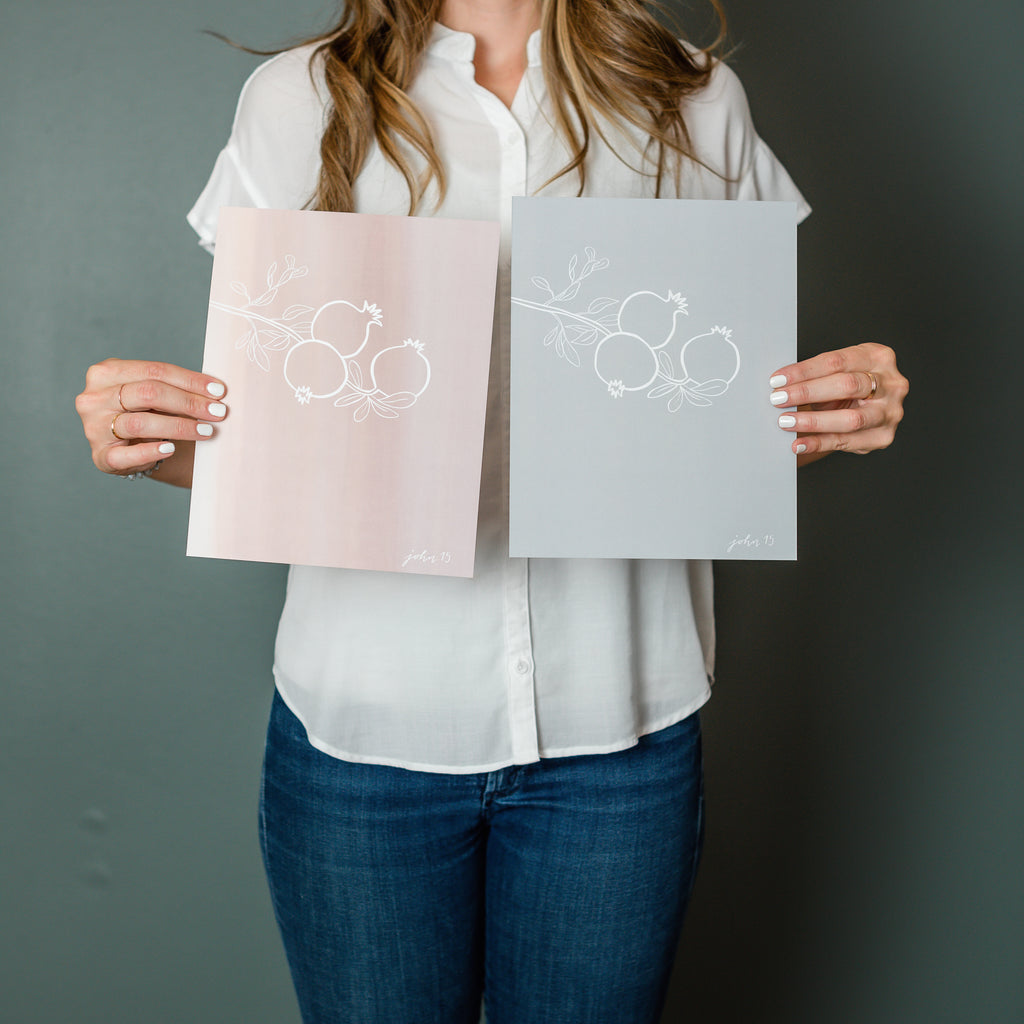 Woman holding John 15 art print in grey and pink