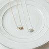 Resolved gold and silver dipped moonstone necklaces on plate