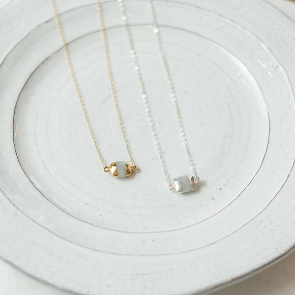Resolved gold and silver dipped moonstone necklaces on plate