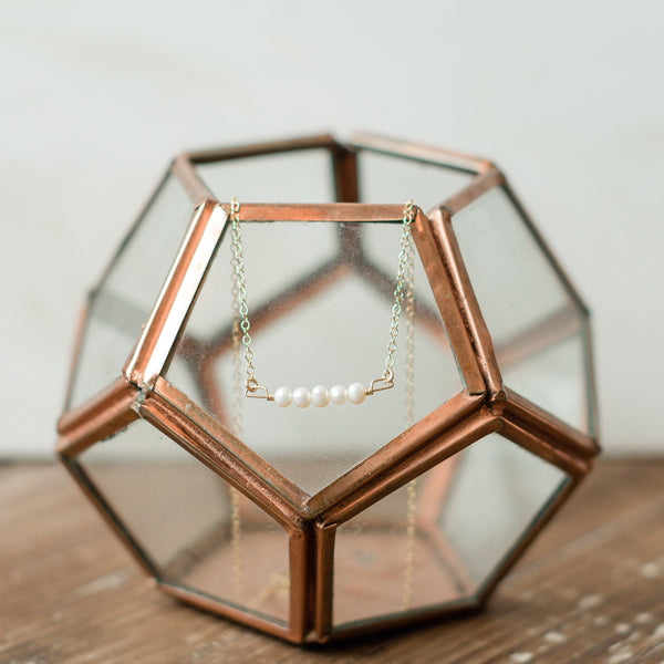 Genuine pearl necklace hanging on glass ball