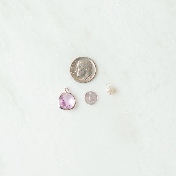 Charms next to a dime for size reference