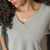Woman wearing gold pendant Guard necklace