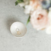Ceramic ring dish holding gold and silver rings