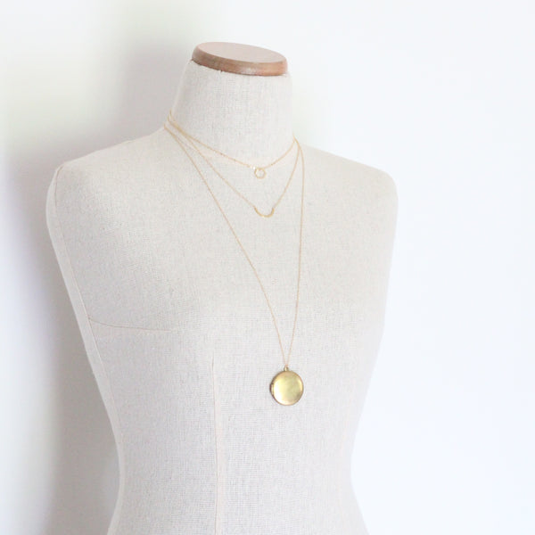 Layered gold necklaces on mannequin