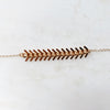 Close up of Onward gold necklace with brass fishtail chain